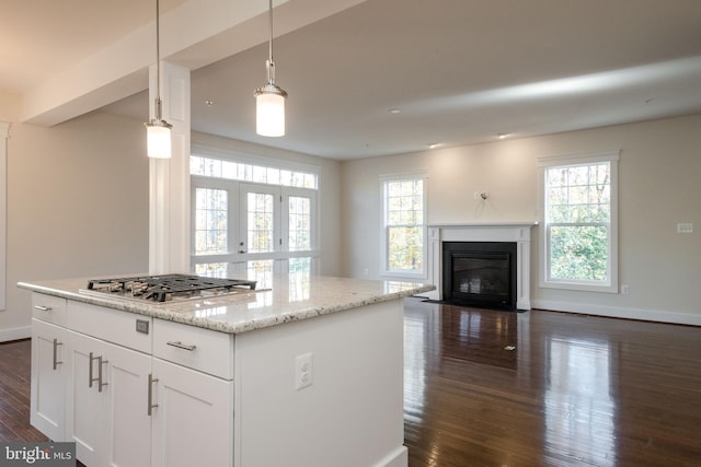 kitchen with dark hardwood / wood-style floors, stainless steel gas stovetop, pendant lighting, white cabinets, and light stone counters