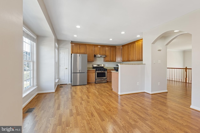 kitchen with light wood-type flooring, appliances with stainless steel finishes, and plenty of natural light