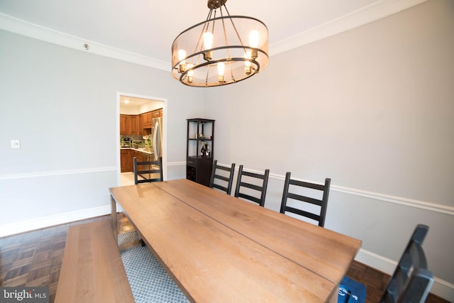 dining area with dark parquet floors, crown molding, and a notable chandelier