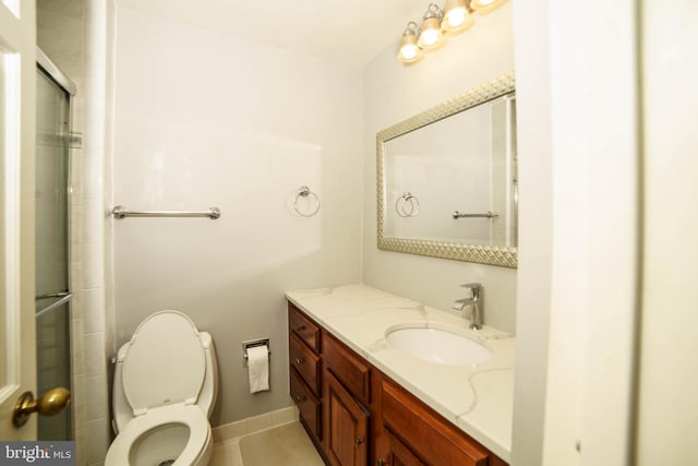 bathroom featuring tile patterned flooring, vanity, a shower with door, and toilet