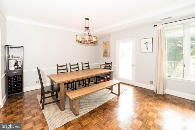 dining area with a chandelier, dark parquet floors, plenty of natural light, and crown molding