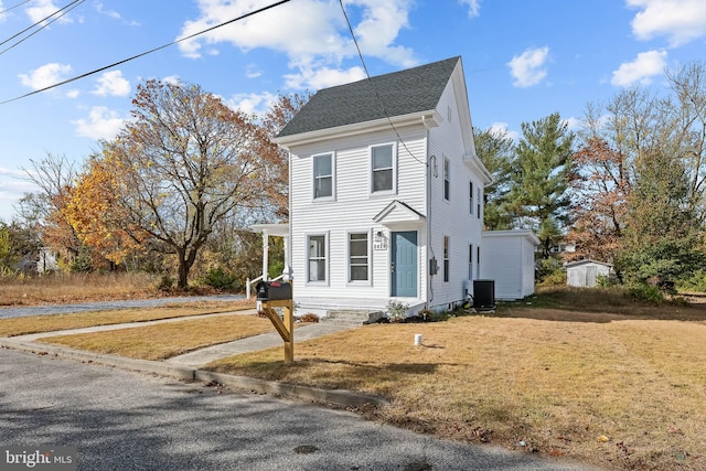 colonial-style house featuring central AC and a front lawn