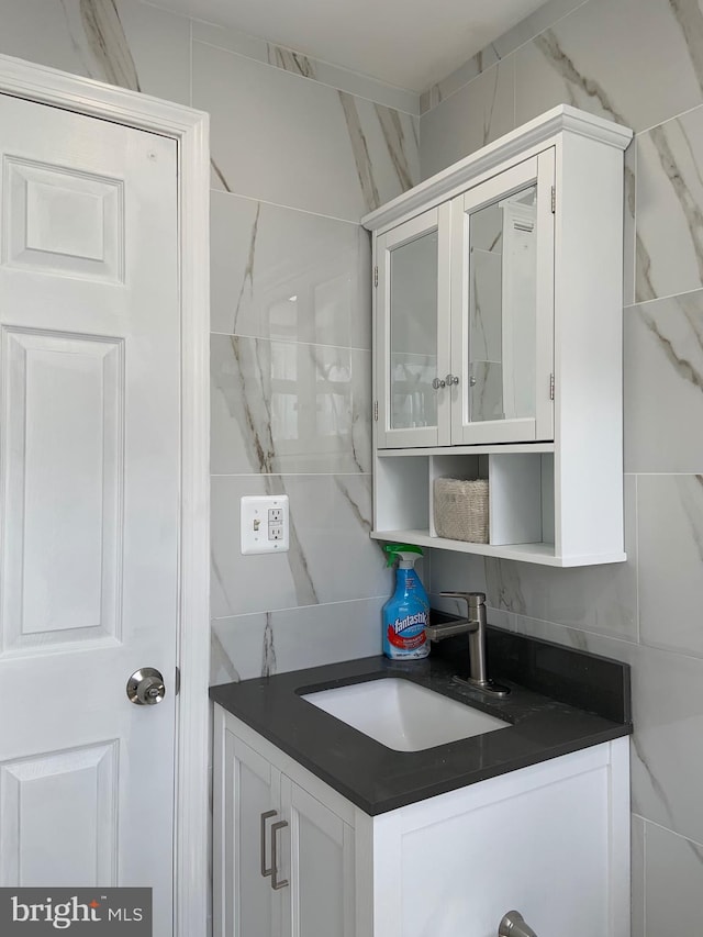 interior space featuring decorative backsplash, sink, and white cabinets