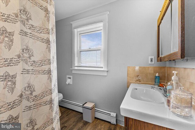 bathroom featuring hardwood / wood-style floors, vanity, toilet, and baseboard heating