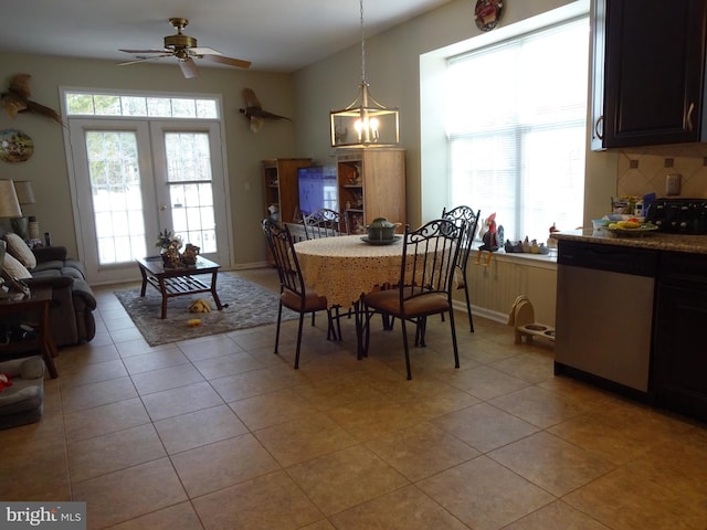 dining room with light tile patterned floors, ceiling fan with notable chandelier, and french doors