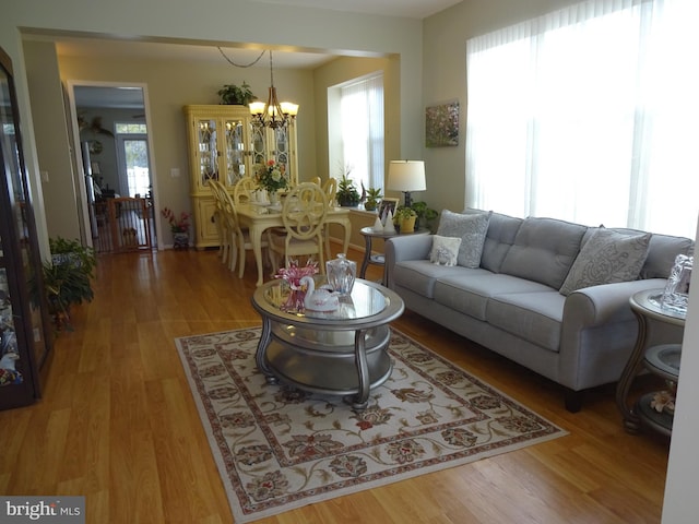 living room with an inviting chandelier and light wood-type flooring