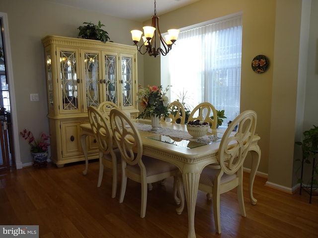 dining room featuring dark hardwood / wood-style flooring and a notable chandelier