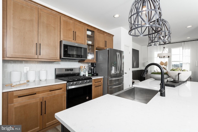 kitchen with sink, tasteful backsplash, decorative light fixtures, stainless steel appliances, and a chandelier