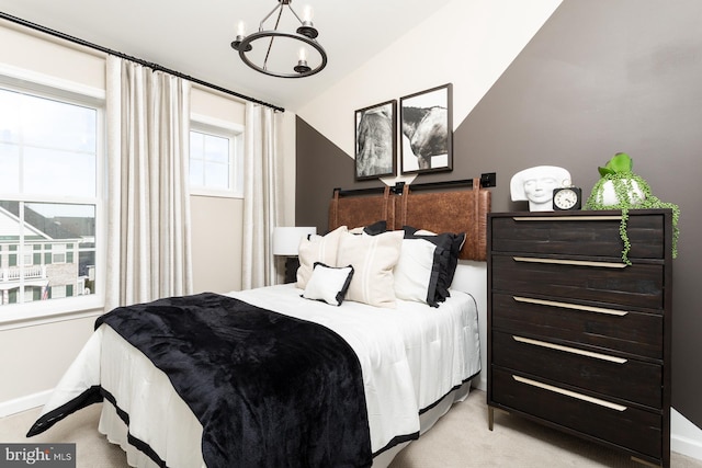 bedroom with lofted ceiling, light carpet, and an inviting chandelier