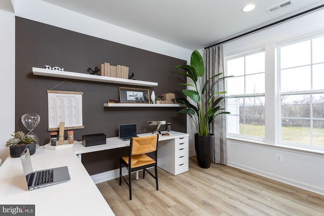 office area with built in desk, a healthy amount of sunlight, and light hardwood / wood-style floors