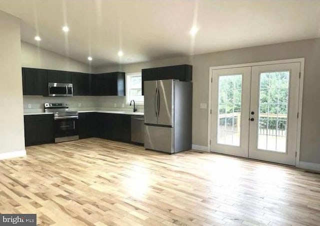 kitchen with light hardwood / wood-style floors, sink, stainless steel appliances, and french doors