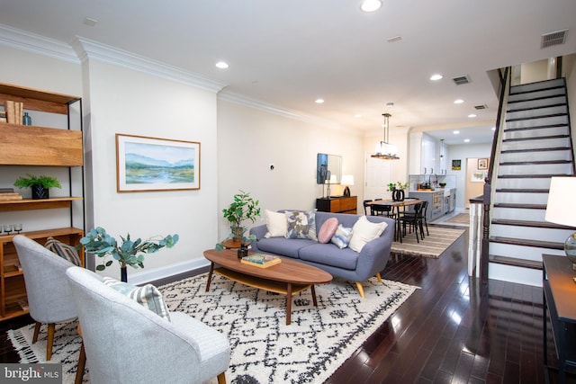 living room featuring ornamental molding, dark hardwood / wood-style floors, and a chandelier