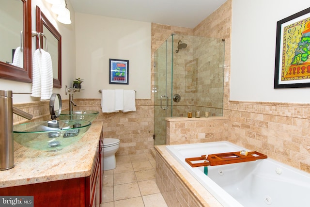 full bathroom featuring tile walls, vanity, separate shower and tub, toilet, and tile patterned floors