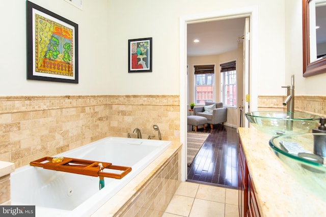 bathroom with vanity, tile patterned flooring, and tiled tub