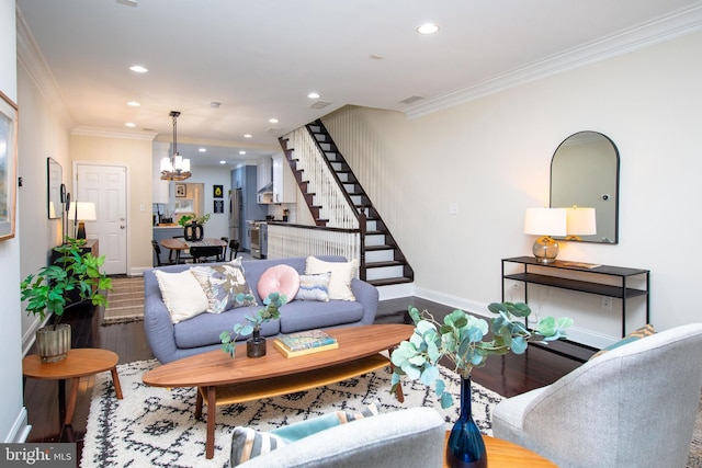 living room featuring an inviting chandelier, hardwood / wood-style floors, and crown molding