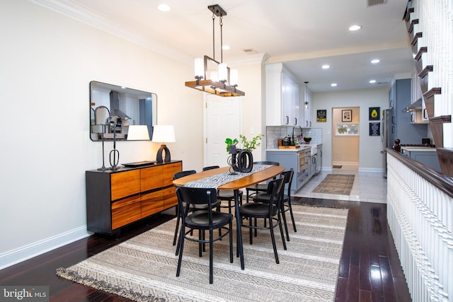 dining space with crown molding and dark hardwood / wood-style flooring