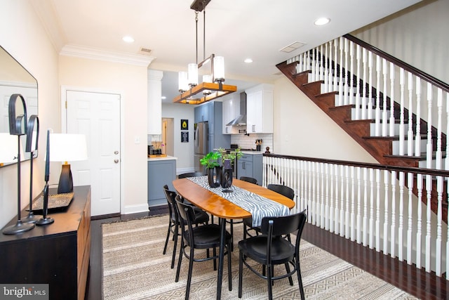 dining area featuring hardwood / wood-style floors and crown molding