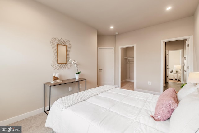 carpeted bedroom featuring a spacious closet and a closet