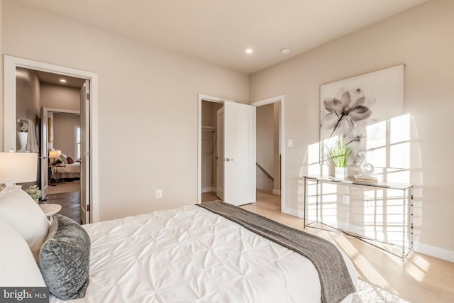 bedroom with a spacious closet, a closet, and hardwood / wood-style floors