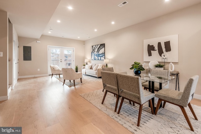 dining space with light hardwood / wood-style floors, electric panel, and french doors