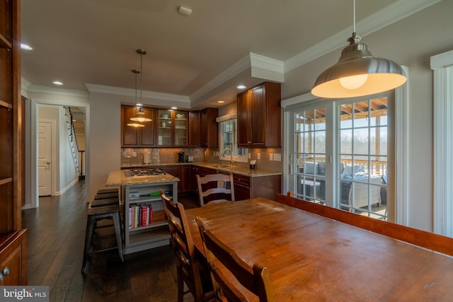 dining room featuring crown molding, dark hardwood / wood-style flooring, and sink