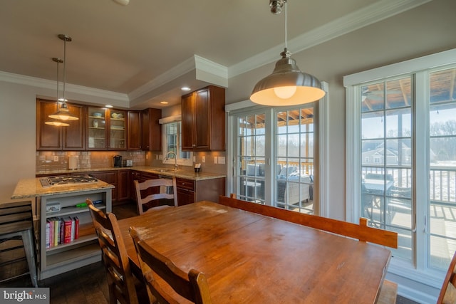 dining space with dark hardwood / wood-style flooring, sink, and ornamental molding