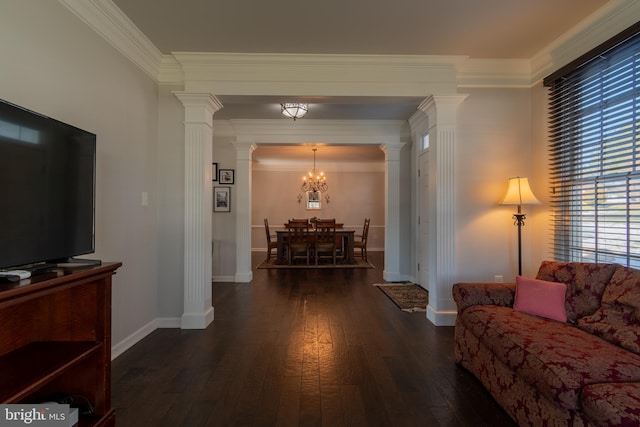 living room featuring an inviting chandelier, ornamental molding, dark hardwood / wood-style floors, and ornate columns