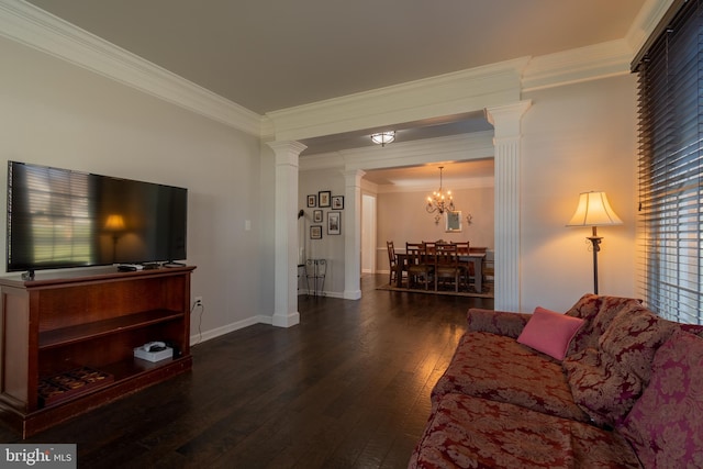 living room featuring ornate columns, ornamental molding, dark hardwood / wood-style floors, and an inviting chandelier