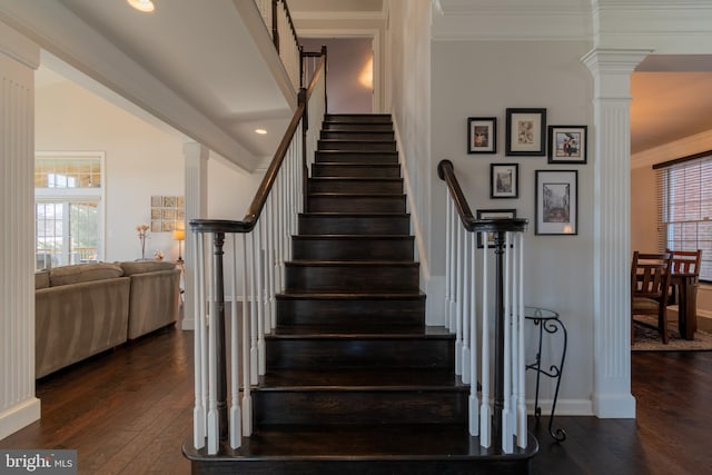 stairway with crown molding, wood-type flooring, and ornate columns