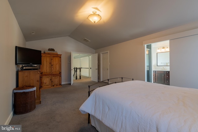 bedroom featuring connected bathroom, vaulted ceiling, and carpet