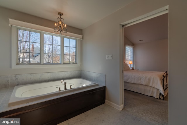 bathroom with a tub and an inviting chandelier