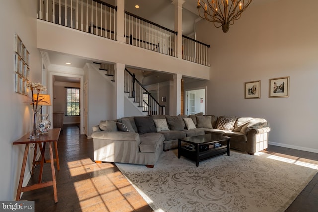 living room featuring crown molding, dark hardwood / wood-style flooring, a chandelier, and a high ceiling