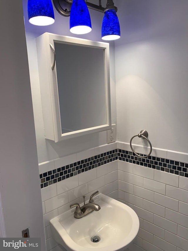 bathroom with sink and tile walls