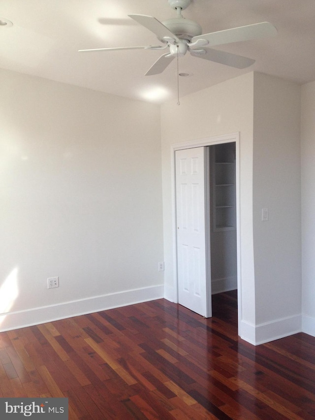 unfurnished bedroom with a closet, ceiling fan, and dark wood-type flooring