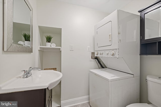 bathroom featuring stacked washer and dryer, vanity, and toilet