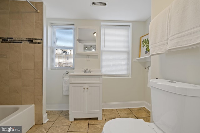 full bathroom with tile patterned floors, vanity, toilet, and tiled shower / bath combo