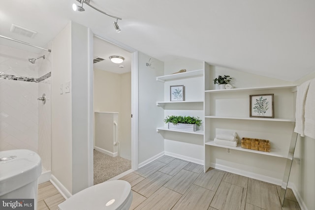 bathroom with lofted ceiling and a tile shower