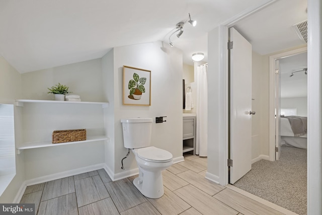 bathroom featuring vaulted ceiling, vanity, and toilet