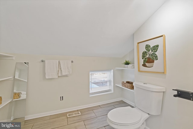 bathroom featuring lofted ceiling and toilet