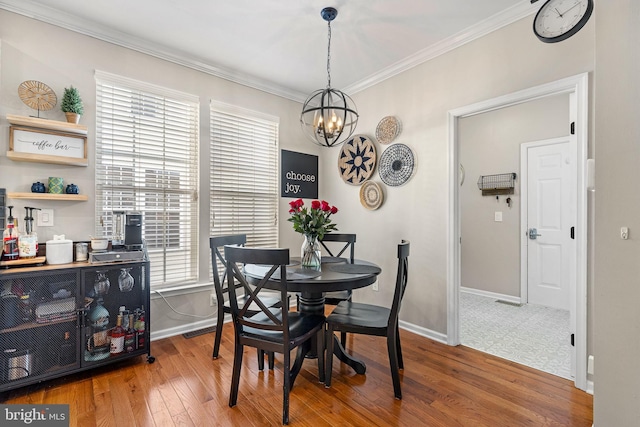 dining area featuring a notable chandelier, wood-type flooring, and crown molding