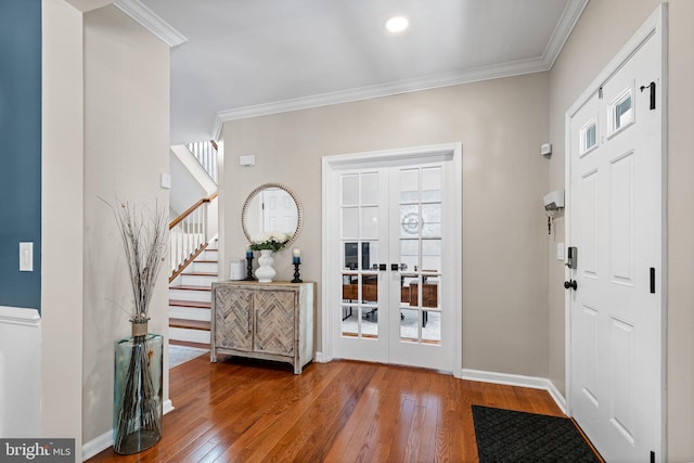 entrance foyer with hardwood / wood-style floors, french doors, plenty of natural light, and crown molding