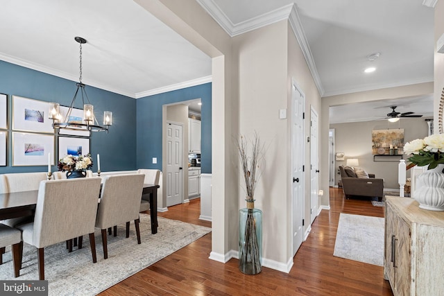 dining space featuring crown molding, dark hardwood / wood-style flooring, and ceiling fan with notable chandelier