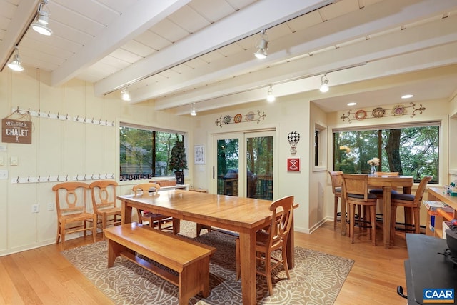 dining space with beam ceiling, wood ceiling, and light hardwood / wood-style floors