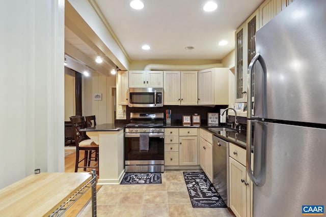 kitchen with a kitchen bar, kitchen peninsula, tasteful backsplash, stainless steel appliances, and sink