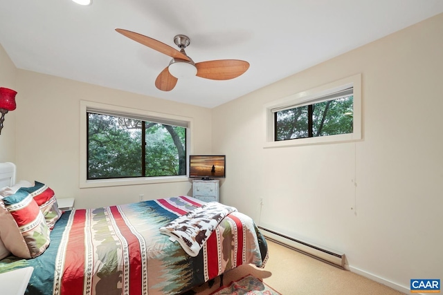 carpeted bedroom featuring multiple windows, baseboard heating, and ceiling fan