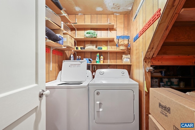 laundry room featuring washer and clothes dryer and wood walls