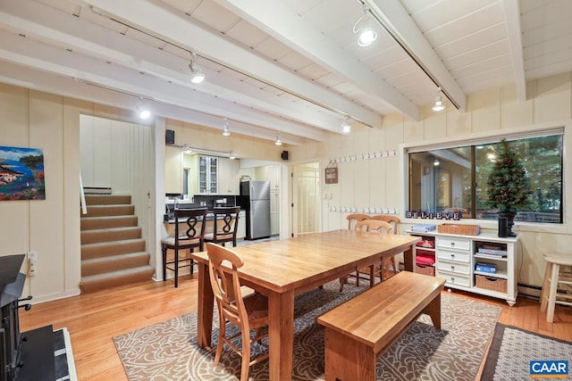 dining space featuring beamed ceiling and light hardwood / wood-style floors