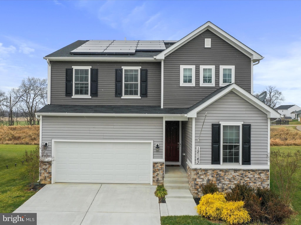 view of front facade with solar panels and a garage