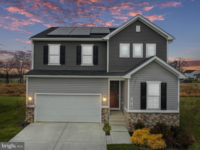 view of front of home featuring solar panels and a garage