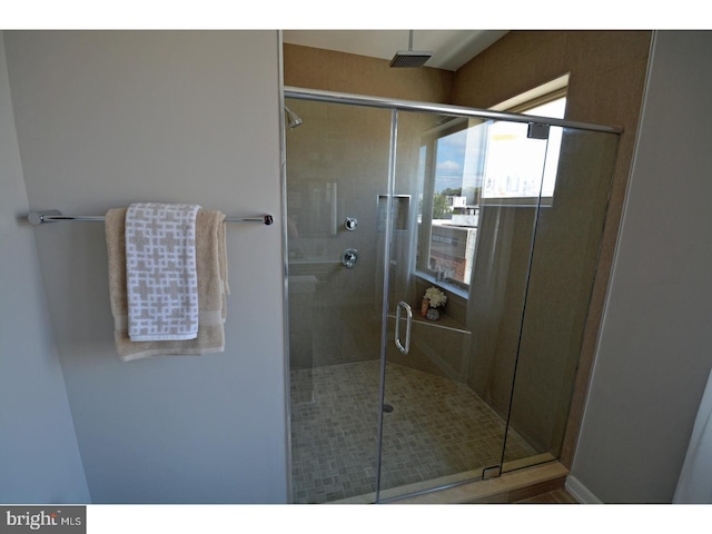 bathroom featuring a shower with door